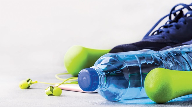 weights headphones running shoes water bottle and smartphone